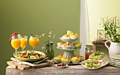 Summer buffet with various dishes, a bunch of flowers and drinks