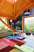 Holzvertäfelter Wohnraum in zeitgenössischer Architektur, Patchworkteppich auf verglastem Bodenbereich