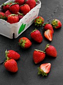 Frische Erdbeeren im Pappschälchen und daneben