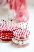 Pin cushions hand-crafted from empty ribbon reels, fabric scraps and odds and ends of trim