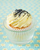 A cupcake with lemon butter cream and poppy seeds