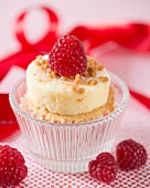 A cheesecake cupcake with raspberries in a glass
