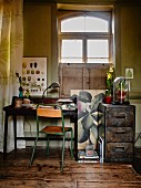 Simple chair with green-painted metal frame at writing desk next to metal filing cabinet below window in vintage interior