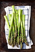 Peeled green asparagus on a tea towel