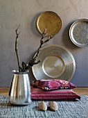 Hand-crafted decorative wall plates, exotic twigs in silver vase and ethnic cushions