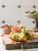 Cauliflower frittata with wild flower cheese and bacon chips on a red pepper sauce