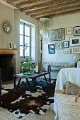 Coffee table on cowhide rug in rustic interior with open fireplace