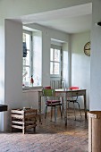 Blick durch breiten Durchgang auf Küchentisch und Vintage Stühle