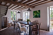 Long wooden table and Thonet chairs in rustic interior with paved floor