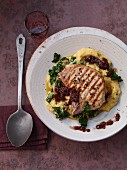 Kale polenta with a pork chop and red onions