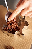 A crispy bunny being made: chocolate rice crispy mixture being placed in a mould