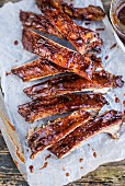 Spicy pork ribs with Bourbon barbecue sauce on paper (close-up)