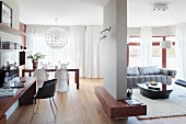 Dining area, seating area and home office against side wall in open-plan, modern interior