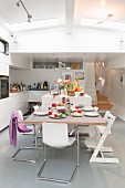Cantilever chairs and Tripp Trapp child's chair around set dining table in open-plan houseboat interior