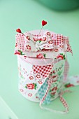 Romantic tin of sewing utensils with heart-headed pins and scraps of rose-patterned fabric