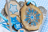 Kleine Baumscheiben als Weihnachtsdekoration, bemalt mit blau-weißem Sternenmotiv