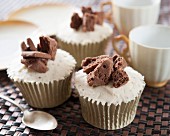 Chocolate cupcakes decorated with frosting and chocolate biscuits
