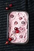 Homemade cherry ice cream in an ice cream container