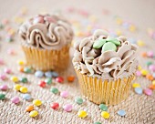 Cupcakes with chocolate cream and colourful chocolate beans