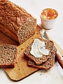 A loaf of wholemeal bread with butter and marmalade