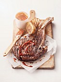 Grilled American ribeye steak, Tomahawk-style with barbecue sauce