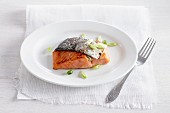 Salmon with fried skin and spring onions