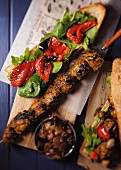 Barbecue skewers with spinach and pepper crostino and caramelised onions