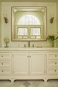 Washstand with marble counter below elegant mirror on wall