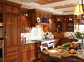 Kitchen-dining room with wooden fronts and wall units in cosy, country-house interior