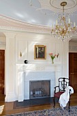 Grand interior with fireplace, chandelier and stucco ceiling rose