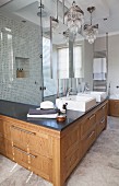 L-shaped washstand counter with solid-wood base cabinet in front of elegant, glazed shower area