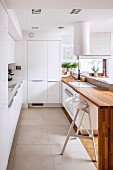 Designer kitchen with smooth, white doors and engineered wood counter