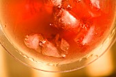 A cranberry cocktail with ice cubes (close-up)