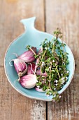 Garlic and flowering thyme in a fish-shaped dish