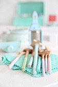 Vintage wooden spoons in pastel shades on turquoise, lacy doily