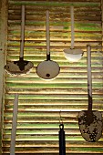 Various ladles hanging from slatted shutter