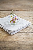 Waxflowers in glass dish on folded cloth