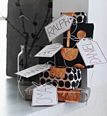 Stack of gifts wrapped in black and white paper with copper accents and name tags