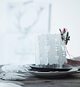 Festive hand-made table centrepiece: candle lantern wrapped in cut-out paper cover