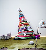 Hand-made Christmas-tree-shaped cushion made from colourful strips of fabric