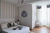 French-style, grey and white bedroom with striped wallpaper and Baroque chair