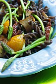 Buckwheat fusilli with wild asparagus, porcini mushrooms, yellow cherry tomatoes and dried tomatoes