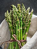 A bundle of green asparagus in a linen cloth
