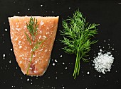 Ingredients for graved salmon: salmon, dill and coarse salt (seen from above)