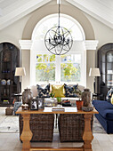 Living room with high ceilings, chandelier and colorful decorative pillows