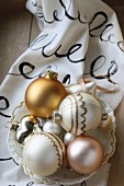 Christmas baubles in vintage bowl on hand-painted fabric