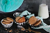 Almond flour and honey cakes in homemade clay dishes with a turquoise lantern and a bottle of milk partially visible in the background