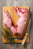 Raw rabbit with rosemary on a wooden chopping board