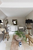 Asparagus fern in spherical vase on rustic wooden table in living room painted pale grey