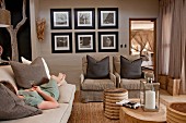 Woman lying on couch and tree-stump coffee tables in living room in various natural shades